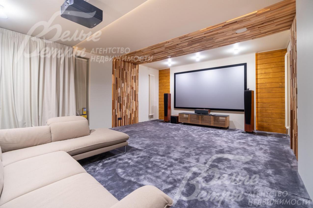 На первом этаже - кинотеатр с экраном 135″. Панно из ценных пород создают выразительные акценты в лестничном холле и кинозале